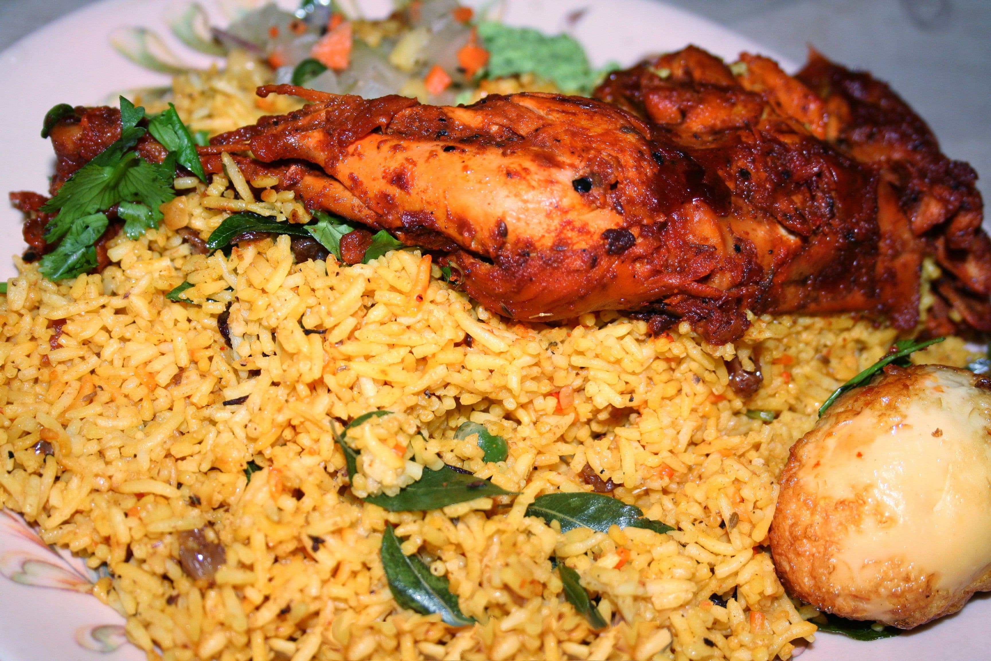 A platter of chicken biryani with layered spiced rice and fried onions