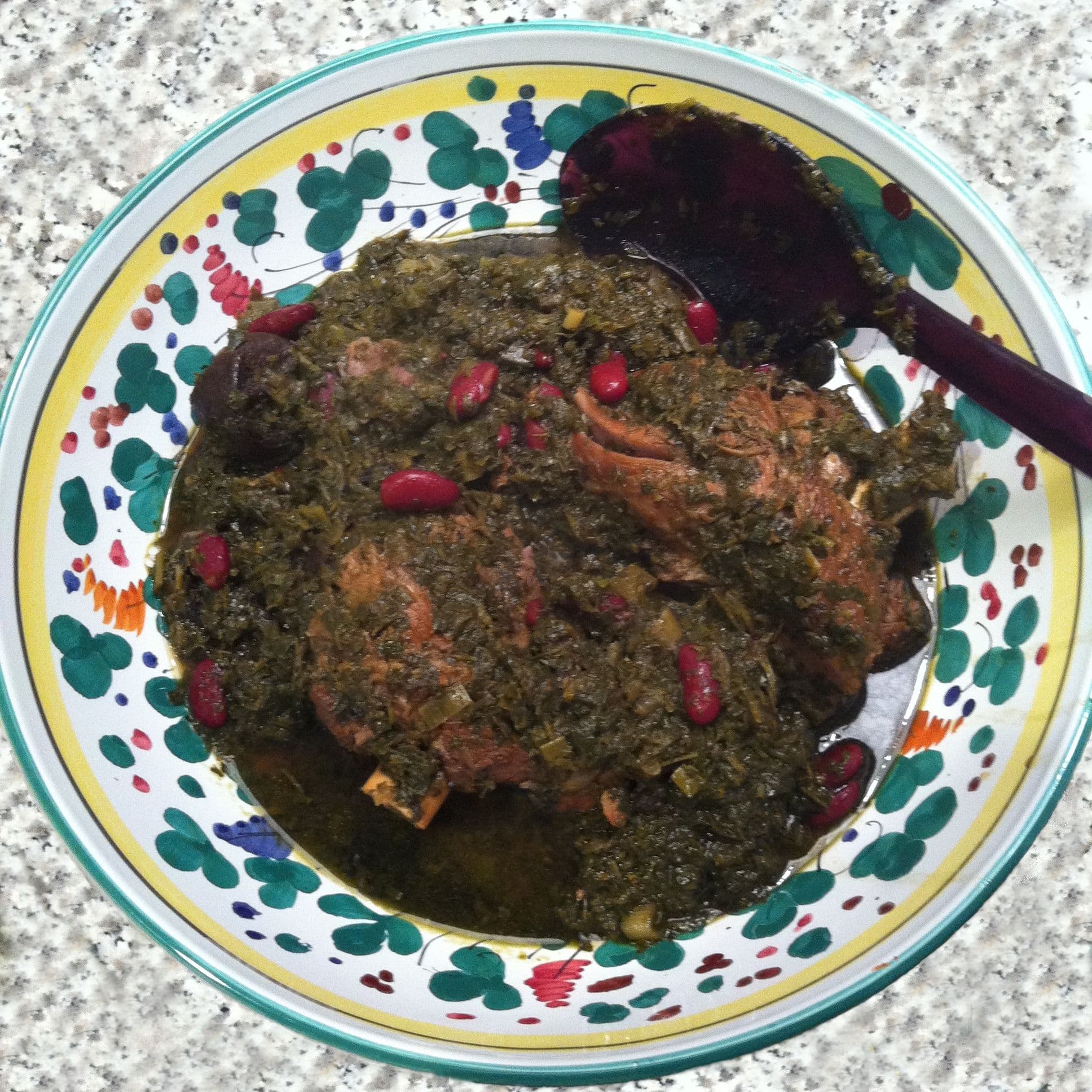 A bowl of ghormeh sabzi, a deep-green Persian herb stew with dried limes